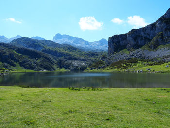 Scenic view of lake by mountains against sky