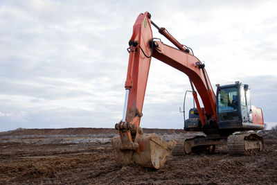 Red excavator during earthworks at construction site. backhoe digging the ground for the foundation