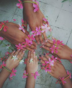 Close-up of hands with flowers over floor