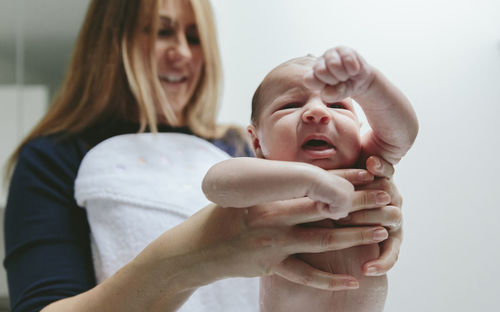 Mother holding wet son at bathroom