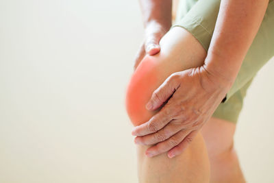 Midsection of woman suffering from knee pain