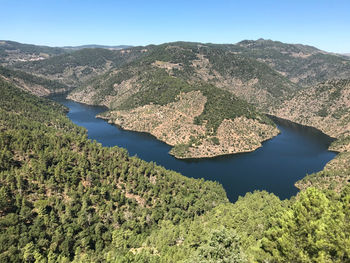 Scenic view of lake and mountains against clear sky