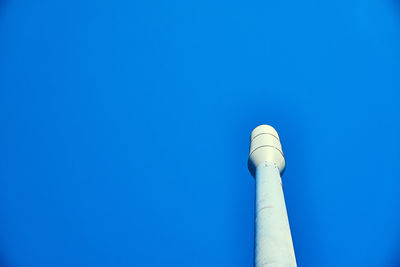 Low angle view of smoke stack against blue sky