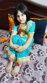 Portrait of smiling girl sitting at toy at home