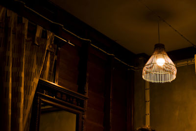 Low angle view of illuminated pendant lights hanging from ceiling