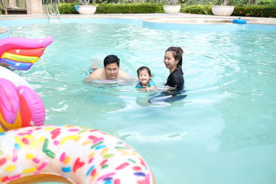 High angle view of siblings swimming in pool