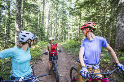 Three female friends mountain bike on a trail at mt. hood, oregon.