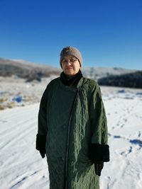 Portrait of woman standing on snow covered land