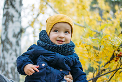 Portrait of cute baby boy against tree