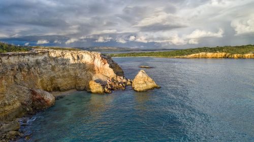 Rock formation in sea against sky