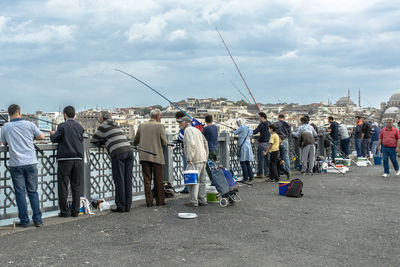 Rear view of people fishing at sea