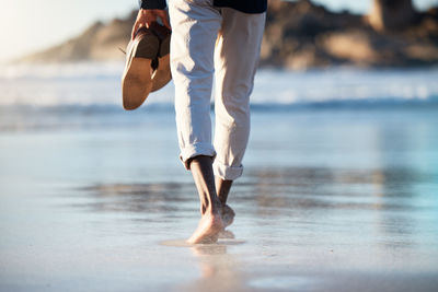 Low section of man running on beach