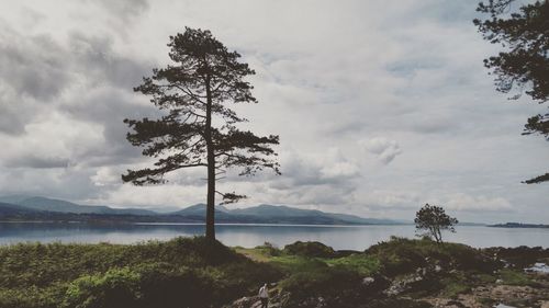 Scenic view of lake against cloudy sky
