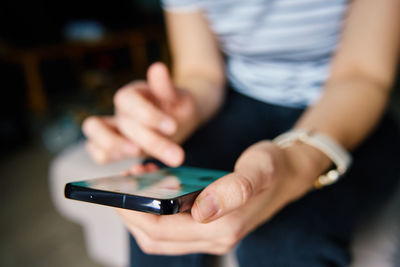 Midsection of man using mobile phone