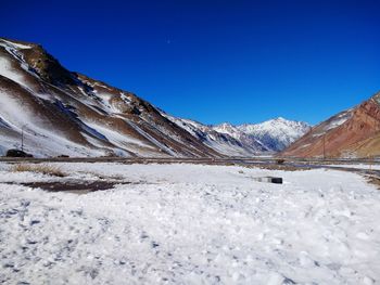 Scenic view of snowcapped mountains against clear blue sky