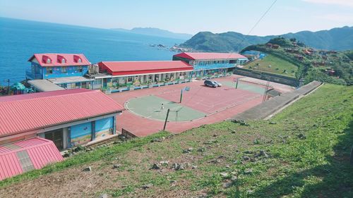 High angle view of buildings by sea against sky