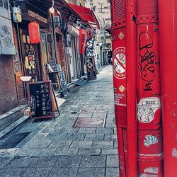 Street light on footpath amidst buildings in city