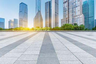 City street by modern buildings against sky