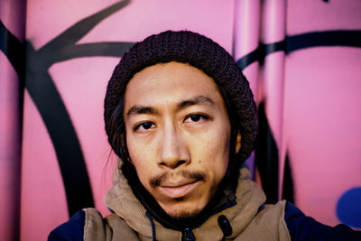 Portrait of young man against pink wall