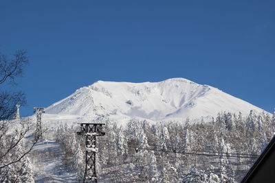 Scenic view of snowcapped mountains against clear blue sky