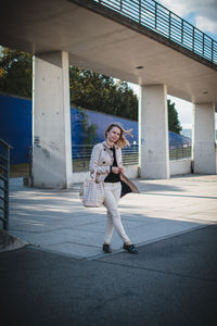 Full length portrait of woman standing on street