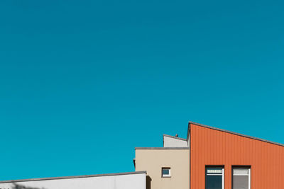 Low angle view of buildings against clear blue sky