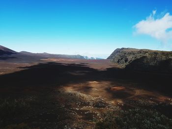 Scenic view of land against blue sky