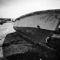 Boat moored on beach against sky