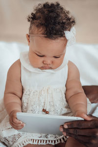 Midsection of baby girl sitting on bed