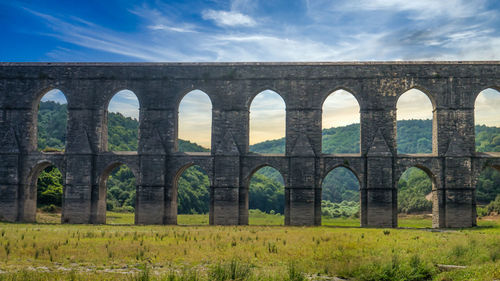 Arch bridge against cloudy sky