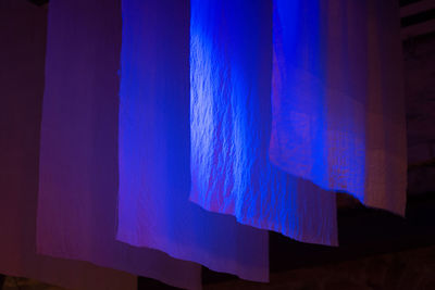 Close-up of blue curtain hanging on wall