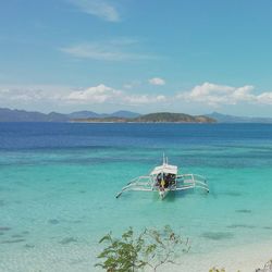 High angle view of outrigger canoe on sea against sky