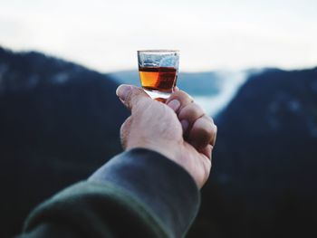 Close-up of hand holding beer glass