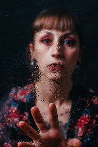 Close-up portrait of a woman over black background