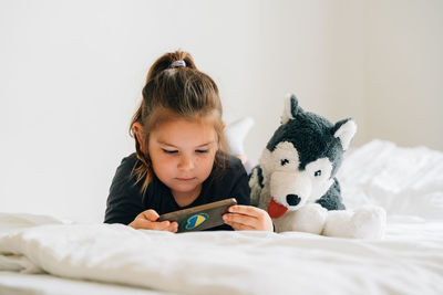 Portrait of boy with dog on bed at home