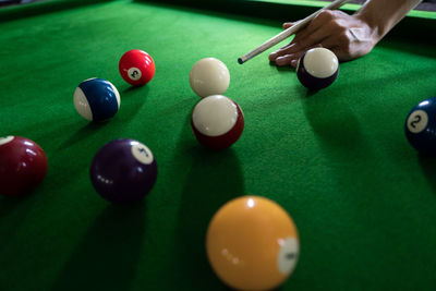 Cropped hand of person playing pool