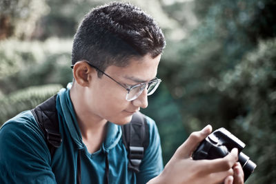 Portrait of a young man using digital camera