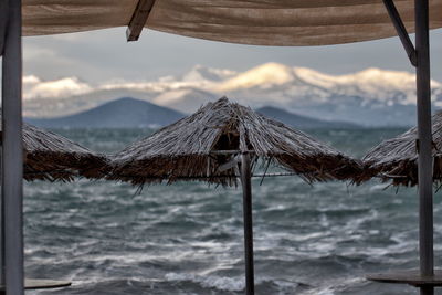 Scenic view of beach and snow-covered mountains against sky