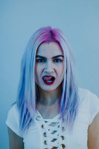 Portrait of beautiful young woman against blue background