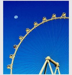 Low angle view of ferris wheel against clear sky