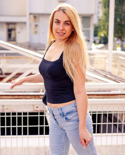 Portrait of young woman standing in city