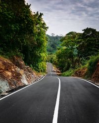 Road amidst trees against sky