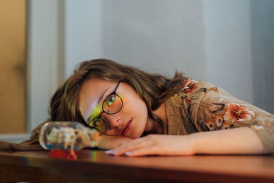 Portrait of young woman lying on table