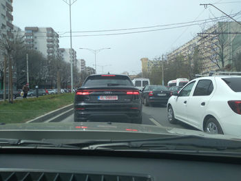 Cars on road in city seen through car windshield