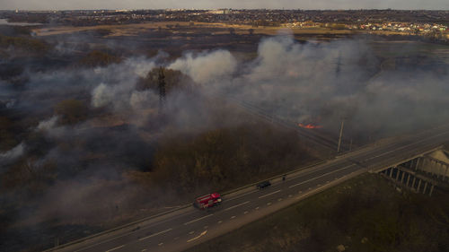 Massive fire, dry grass lanes in fire, firefighters at work, disaster, ecological catastrophe