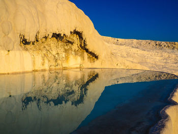 Scenic view of hot spring against clear blue sky at pamukkale