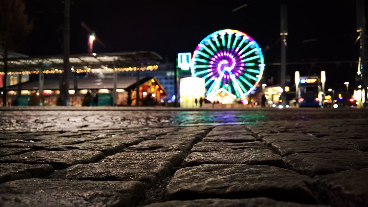 ILLUMINATED FERRIS WHEEL BY CITY AT NIGHT