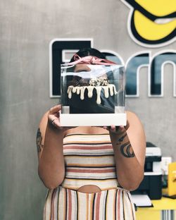 Midsection of person holding text against wall