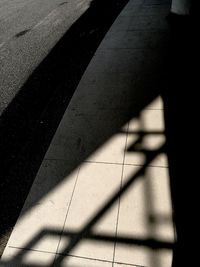 Low section of shadow on tiled floor
