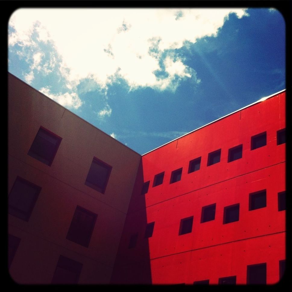 architecture, low angle view, building exterior, built structure, window, sky, transfer print, auto post production filter, building, residential structure, cloud - sky, red, day, residential building, cloud, outdoors, no people, blue, sunlight, high section